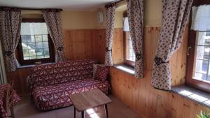 uma sala de estar com um sofá e janelas em Casa Vacanze: Maison Des Gnomes em Challand Saint Anselme