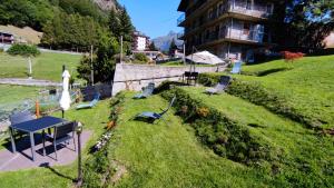 a garden with a table and chairs and a building at Casa Vacanze: Maison Des Gnomes in Challand Saint Anselme