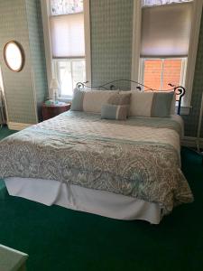 uma cama grande num quarto com alcatifa verde em Hotel St Nicholas em Cripple Creek