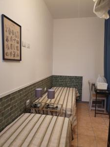 um quarto com duas camas e uma mesa com candeeiros em casa turro em Milão