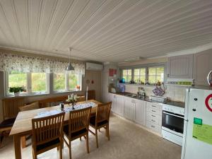 a kitchen with a wooden table and chairs in a kitchen at Joarsbo, Stuga 1, Sjölyckan in Kalv