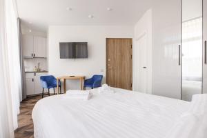 een slaapkamer met een groot wit bed en blauwe stoelen bij Seaside Central Hotel in Palanga