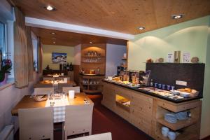 a restaurant with a counter with food on it at Hotel Garni & Aparthotel COLLINA in Ischgl