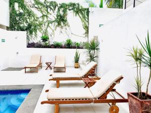 une terrasse avec des chaises longues et une piscine dans l'établissement Florence Sayulita, à Sayulita