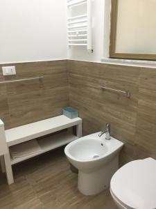 een badkamer met een wit toilet en een wastafel bij LoVi apartments Porto Palo in Porto Palo