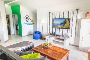Una sala de estar con un sofá y un televisor. en Cantinho da Micas, en Calheta
