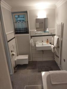 a white bathroom with a sink and a toilet at Salzufler Wohntraum in Bad Salzuflen