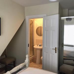 a bathroom with a sink and a bathroom with a stairway at The Strand Guest House in Falcarragh