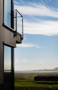 un edificio con una ventana en el lateral. en Black Beach Suites en Vík