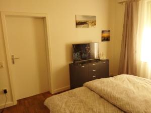 a bedroom with a bed and a flat screen tv at Salzufler Wohntraum in Bad Salzuflen