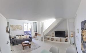 a white living room with a couch and a tv at R.D.V. Duplex Nice Center in Nice