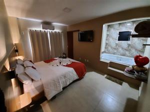 a bedroom with a bed and a large window at Terra D` Ouro Apart Hotel in São João del Rei