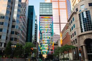 a tall building with many windows in a city at Hôtel Le Germain Montréal in Montreal