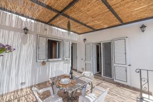 a patio with a table and chairs and a wooden ceiling at Casa Antonia in Anacapri