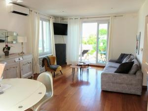 ein Wohnzimmer mit Sofa und Tisch in der Unterkunft Suite sur la mer Marseille Corniche in Marseille