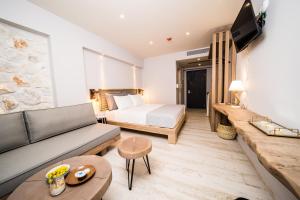 ein Wohnzimmer mit einem Sofa und einem Bett in der Unterkunft Kali Thea Suites in Neos Marmaras