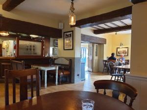 ein Esszimmer mit einem Tisch und Tischen in der Unterkunft The Cheney Arms in Gaddesby