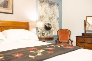 a bedroom with two beds and a table and a chair at The Cheney Arms in Gaddesby