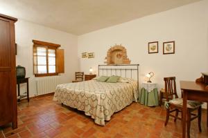 1 dormitorio con 1 cama, mesa y sillas en Podere Il Pero en Siena