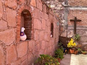 a brick wall with a statue of a bird in a window at Manzano B&B in Guanajuato