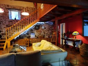 Casa Rural Alto Santiago في Santiago del Collado: غرفة معيشة مع أريكة ودرج