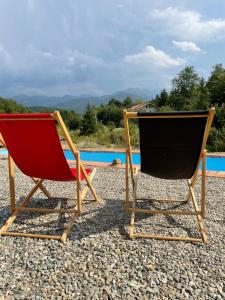 two chairs sitting on the beach near a pool at Porumbacu Mountain Views - Cabană cu Piscină in Porumbacu de Sus