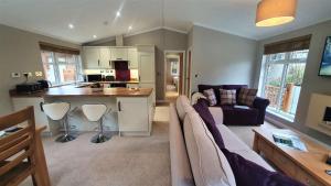a kitchen and living room with a couch and a table at Llyn Alwen Lodge Snowdonia National Park in Betws-y-coed +10 photos