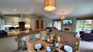 a kitchen and a living room with a table and chairs at Llyn Alwen Lodge Snowdonia National Park in Betws-y-coed