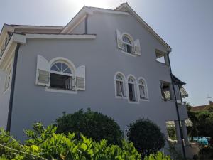 une maison blanche avec des fenêtres et des buissons dans l'établissement Villa Triton, à Pula