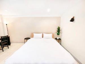 ein Schlafzimmer mit einem großen weißen Bett mit zwei Kissen in der Unterkunft Grand Residence in Bangkok