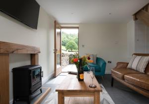 a living room with a couch and a tv and a table at Tyddyn at Hendre Rhys Gethin in Betws-y-coed