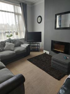 a living room with a couch and a fireplace at Sandyrise holiday lets in Scarborough
