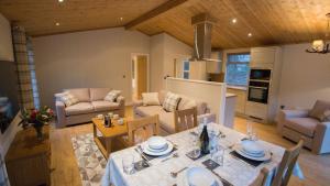 a kitchen and living room with a table and chairs at Llyn Brenig Lodge in Betws-y-coed