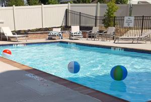 uma piscina com duas bolas na água em Holiday Inn Express Bordentown - Trenton South, an IHG Hotel em Bordentown