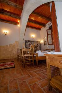 um quarto com uma cama, uma mesa e cadeiras em STAMATOGIANNIS Traditional Apartments em Kalivianí