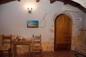 a dining room with a table and a wooden door at STAMATOGIANNIS Traditional Apartments in Kalivianí