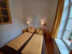 a bedroom with a bed with two pillows and a window at FeWo "Biene" im Kunstgut Krahne in Lehnin