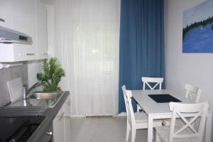 a kitchen with a table and chairs in a kitchen at BlueSolarPearl B - vaihtoehto majoittumiselle in Linnavuori