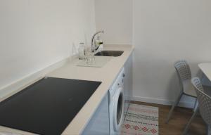 a kitchen with a sink and a washing machine at Voga Voga in Corcubión +12 photos