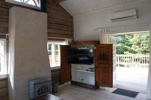 una sala de estar con TV de pantalla plana en una habitación con ventanas en Latitude, en Torestorp