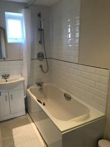 een witte badkamer met een bad en een wastafel bij Springfield in Oakham