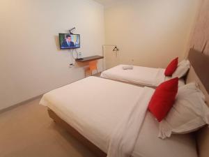 
A bed or beds in a room at OYO 90473 Gowin Hotel
