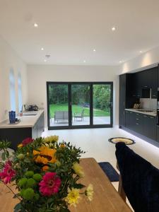 a kitchen and living room with a table and flowers at Crossing Cottage sleeps 6 with private parking,ideal for contractors , Newark in Staythorpe