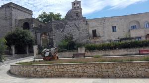 a stone building with a statue in front of it at B&B CASAVACANZE CHIESA MADRE in Carovigno
