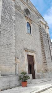 a brick building with a door and a plant in front at B&B CASAVACANZE CHIESA MADRE in Carovigno