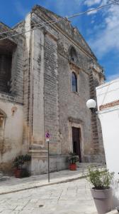 an old brick building with a sign in front of it at B&B CASAVACANZE CHIESA MADRE in Carovigno