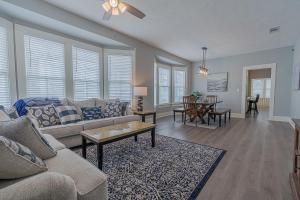 a living room with a couch and a table at Uptown Cottage Newly Updated Home Near the Strand Galveston Harbor and UTMB in Galveston