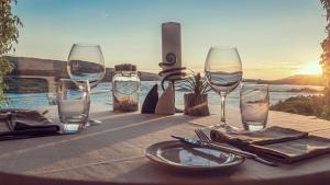Ardagh Hotel & Restaurant في كليفدين: طاولة مع كؤوس للنبيذ وصحن عليها
