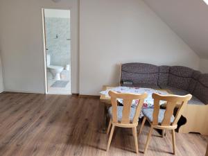 a dining room table with two chairs and a couch at Studentská apartments in Karlovy Vary