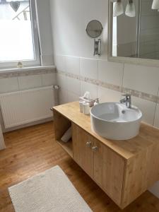 ein Bad mit einem Waschbecken und einem Spiegel in der Unterkunft B&B Penzion in Diez